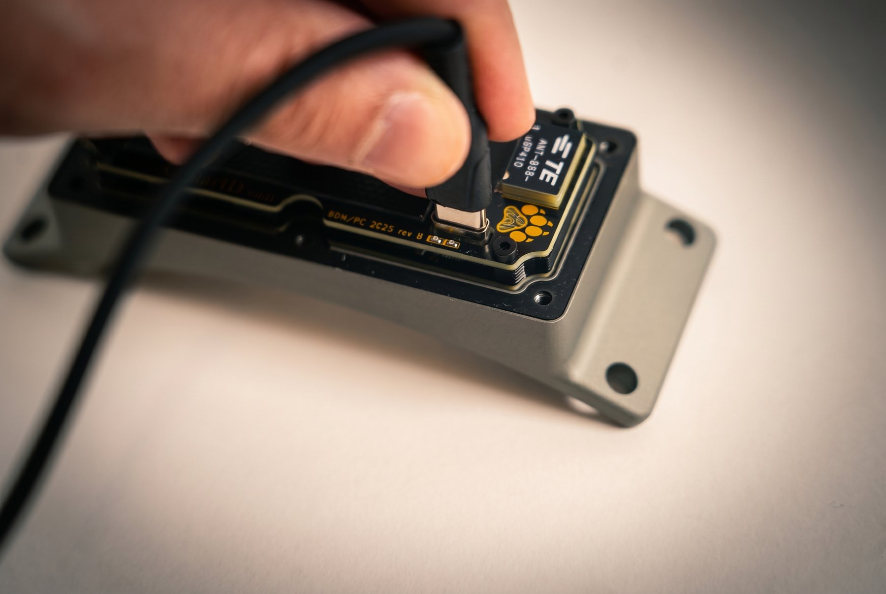 USB-C cable plugged into the port on the top edge of the front PCBA, cover removed